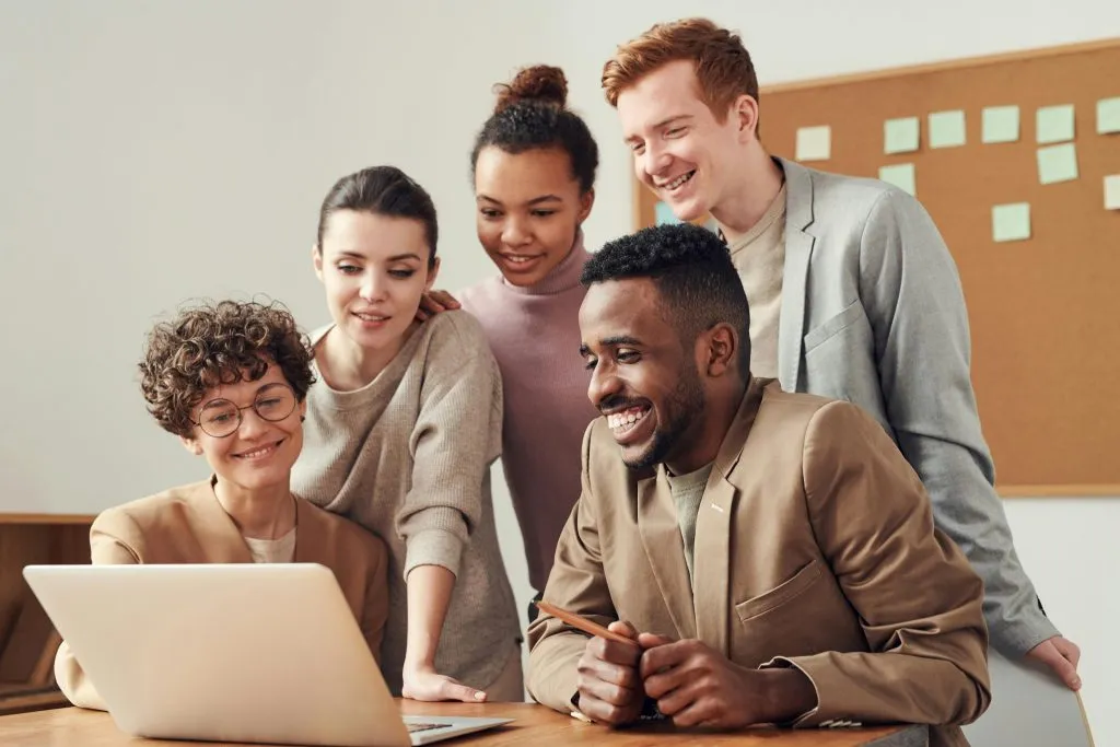 Vielfältiges Team arbeitet gemeinsam am Laptop – das AGG schützt vor Benachteiligung am Arbeitsplatz.