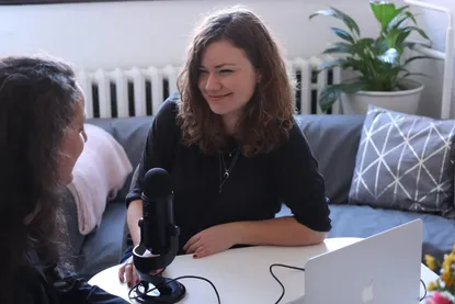 Smartphone auf einem Stativ nimmt eine Frau für ein Schulungsvideo im Büro auf
