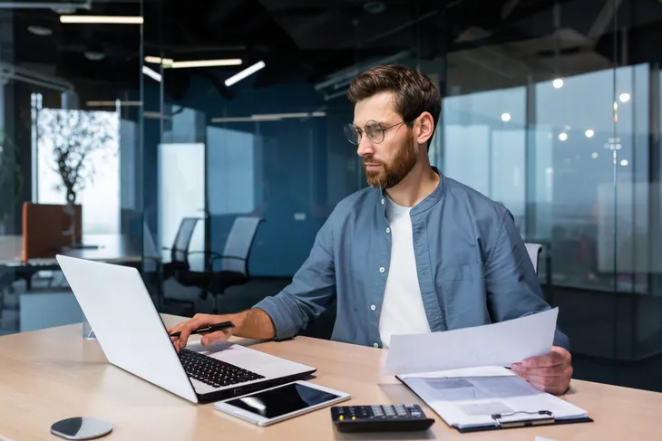 Mann mit Brille prüft am Laptop die Unterlagen für einen Unterweisungsnachweis